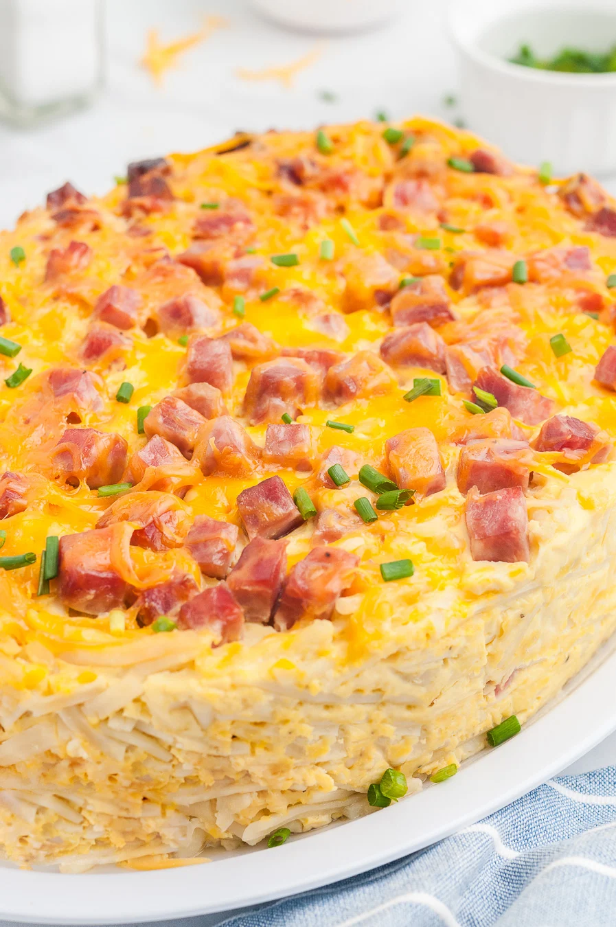 Ham and cheddar breakfast casserole prepared in an oval slow cooker, placed onto a plate for serving.