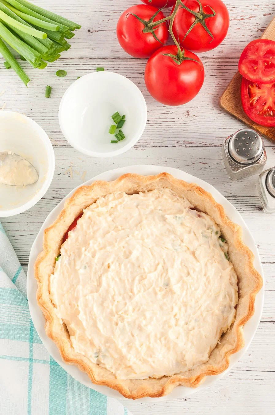 layer of mayo being added to tomato pie