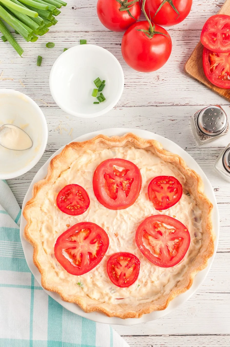 Adding a layer of sliced tomatoes to tomato pie