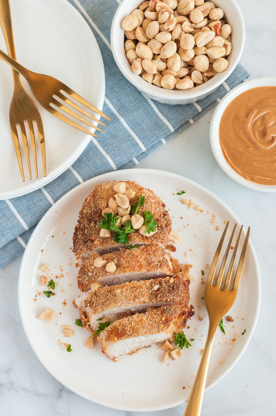 sliced chicken breast with peanuts and parsley garnish on top