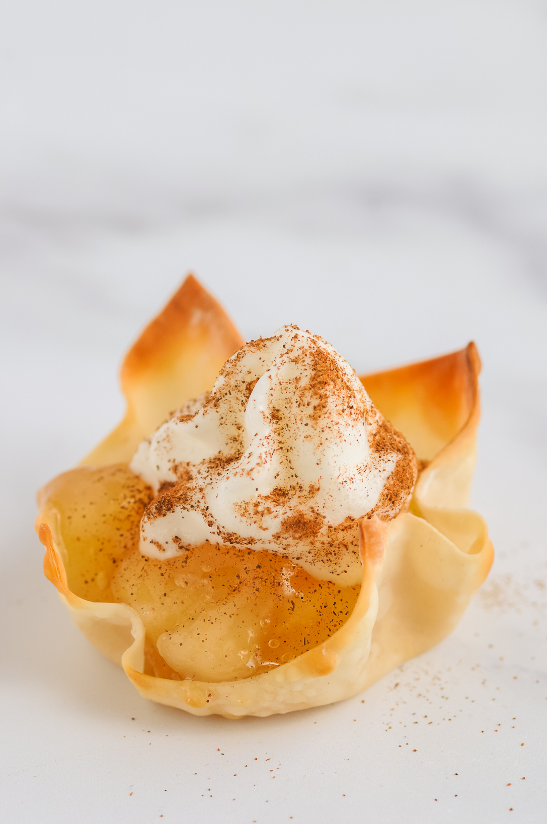 Whipped Topping on top of apple pie wontons.