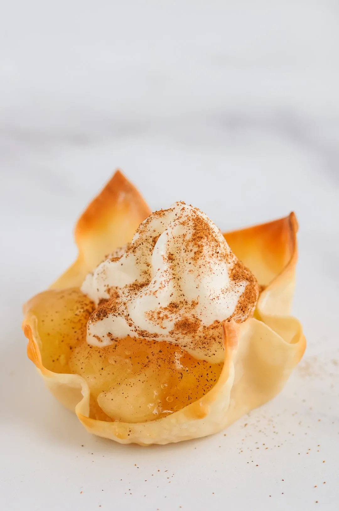 Whipped Topping on top of apple pie wontons.
