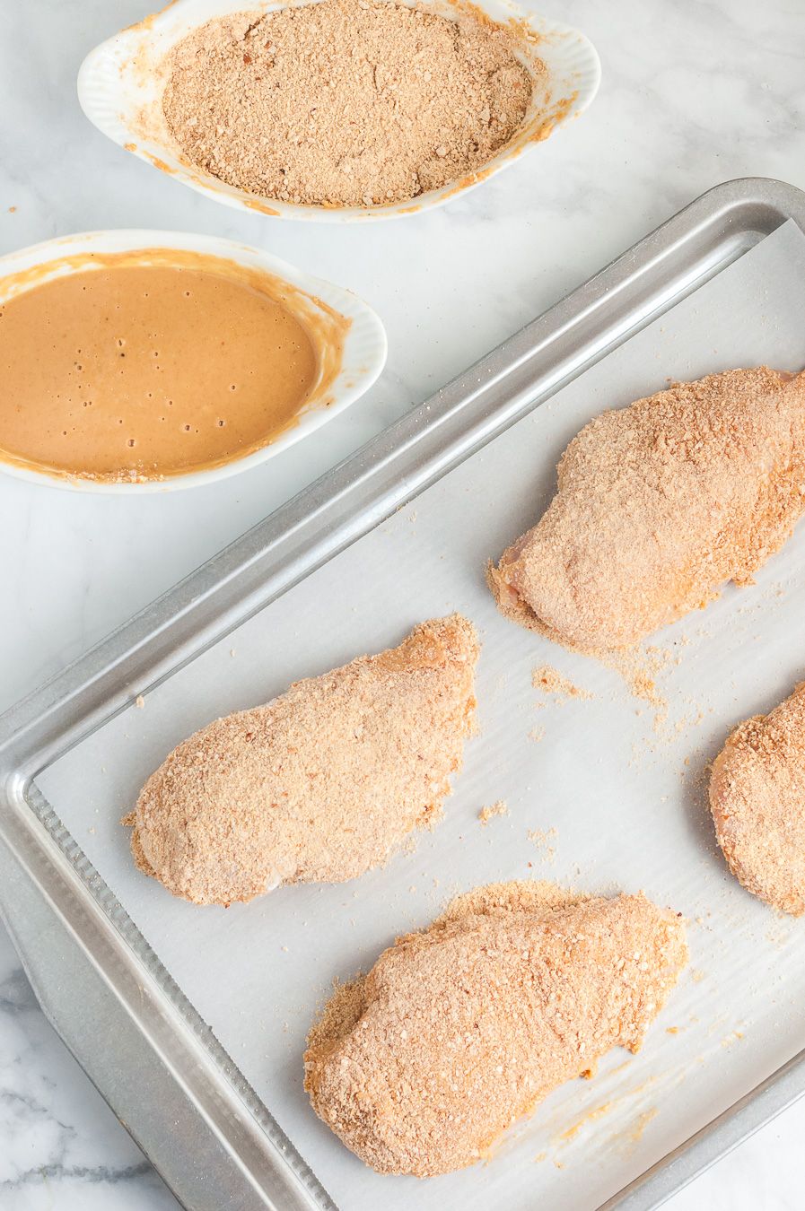 crusted chicken breast on baking sheet