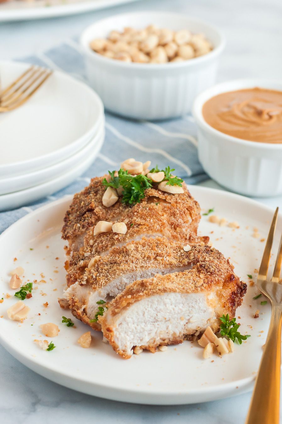 sliced crusted chicken breast with parsley and peanut garnish