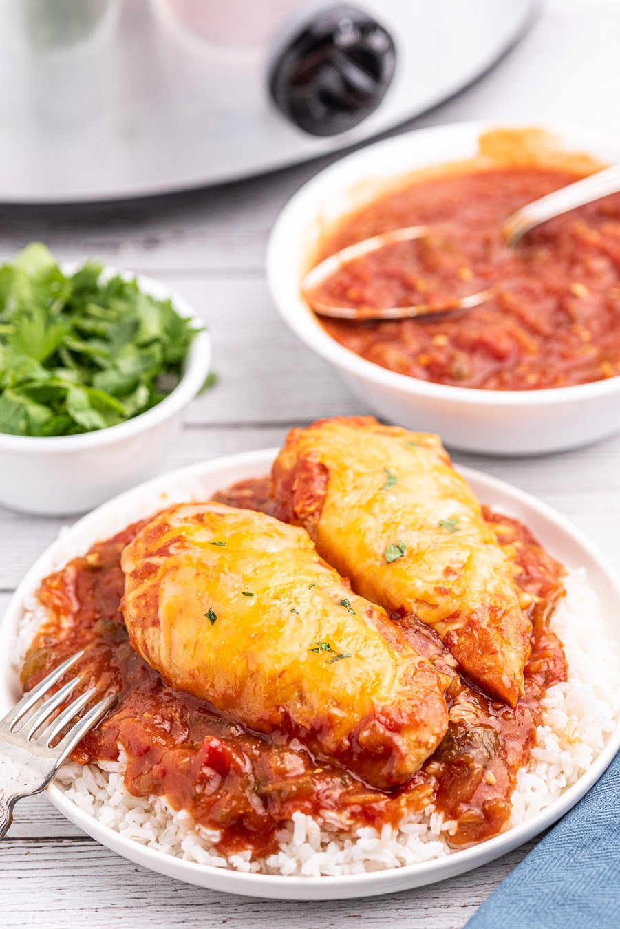 easy fiesta chicken made in a slow cooker, plated with slow cooker in background