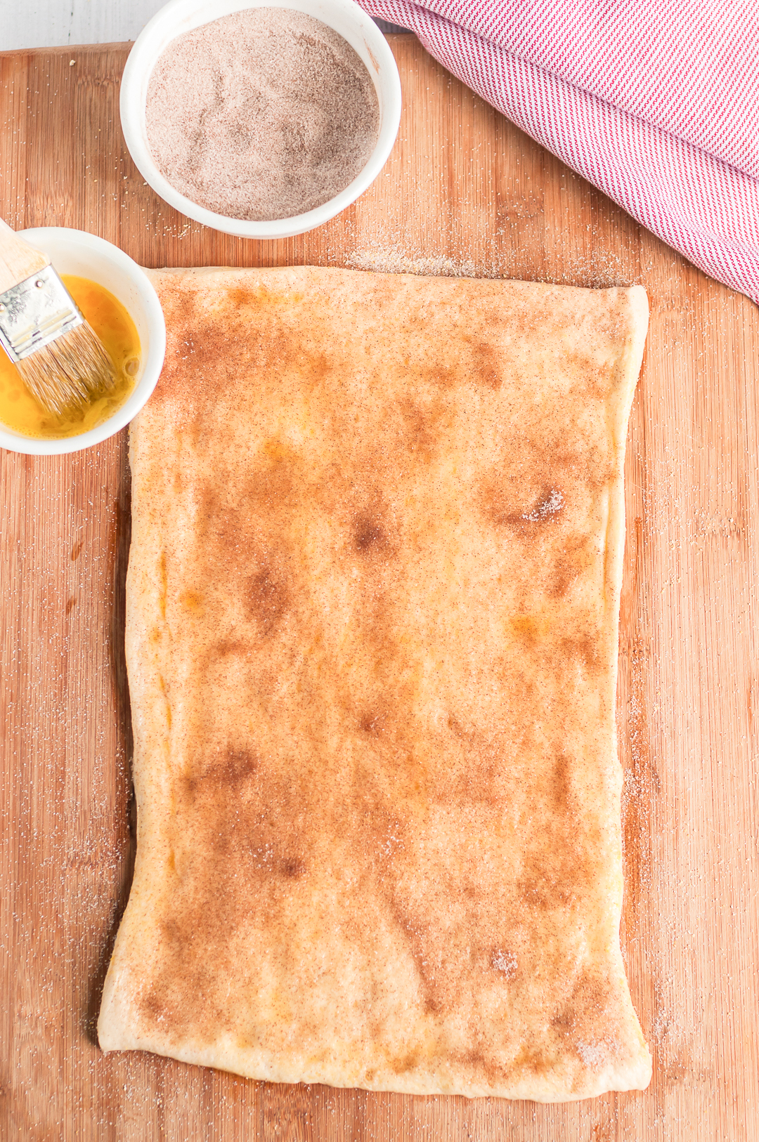 Pizza dough rolled out with cinnamon and sugar