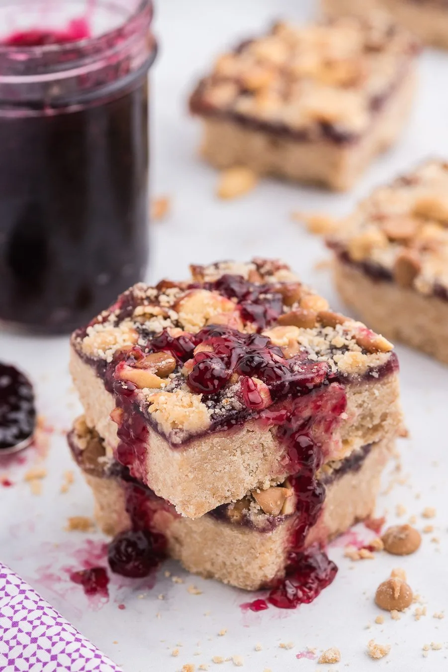 peanut butter and jelly bars with oozing jelly, chopped peanuts and peanut butter chips