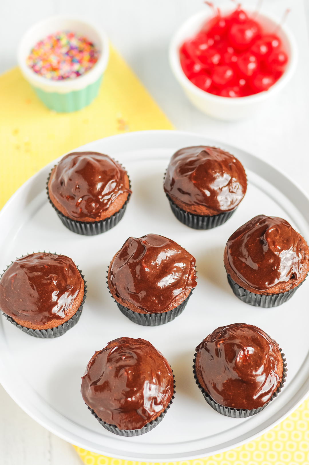 adding chocolate ganache to cupcakes