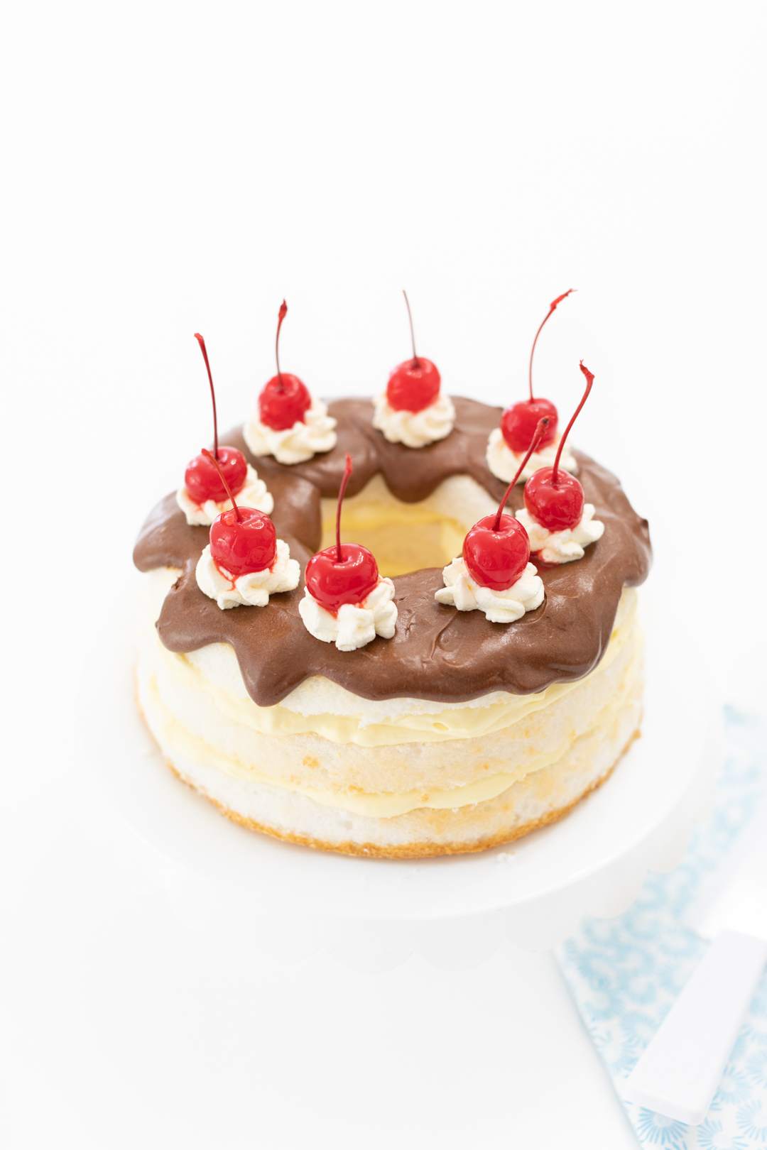 pretty chocolate covered cake with layers of pudding and topped with pretty cherries