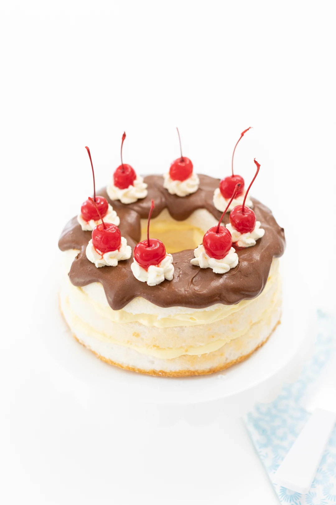 pretty chocolate covered cake with layers of pudding and topped with pretty cherries