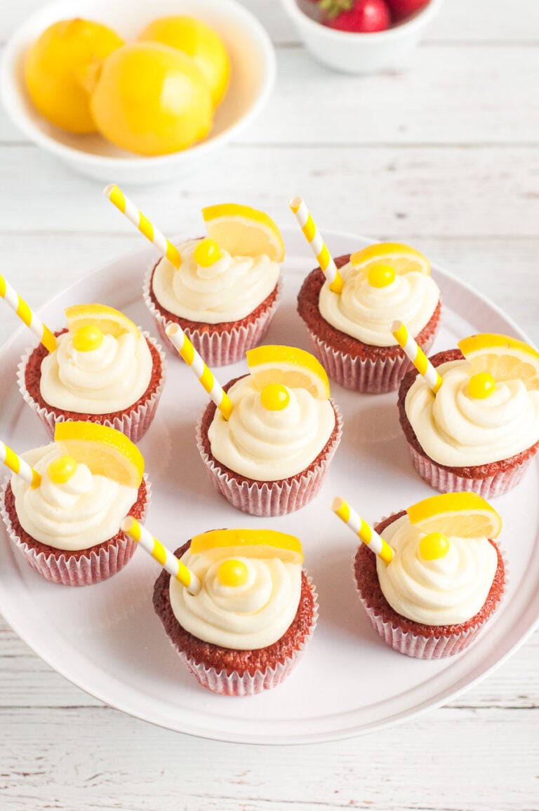 tray of lemon cupcakes up close. lemon wedge for garnish