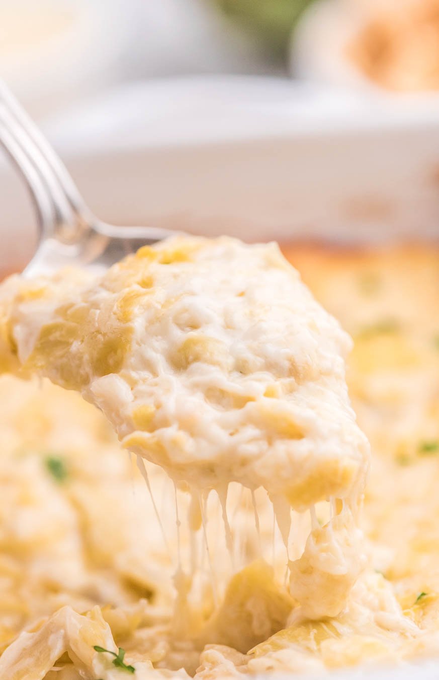 up close view of artichoke dip with melty cheese