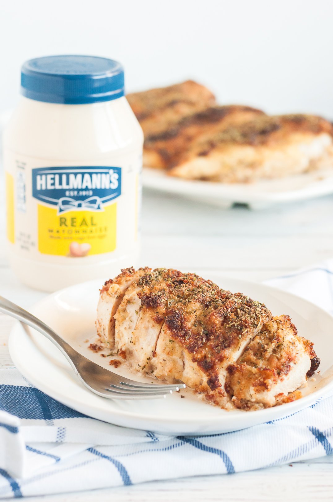 moist baked chicken with parmesan crust on top. mayo jar in the background