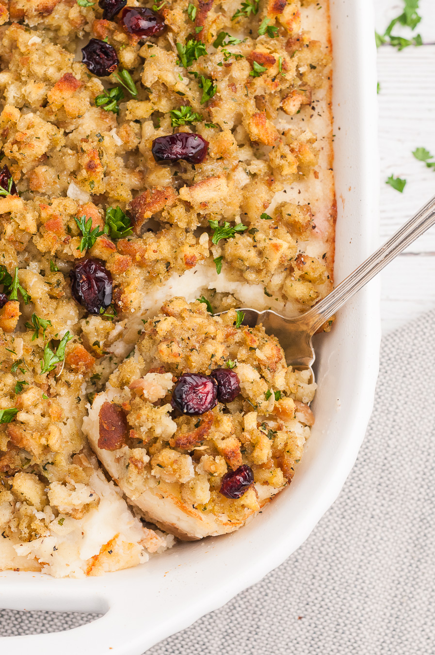 spoonful of casserole with stuffing and cranberries