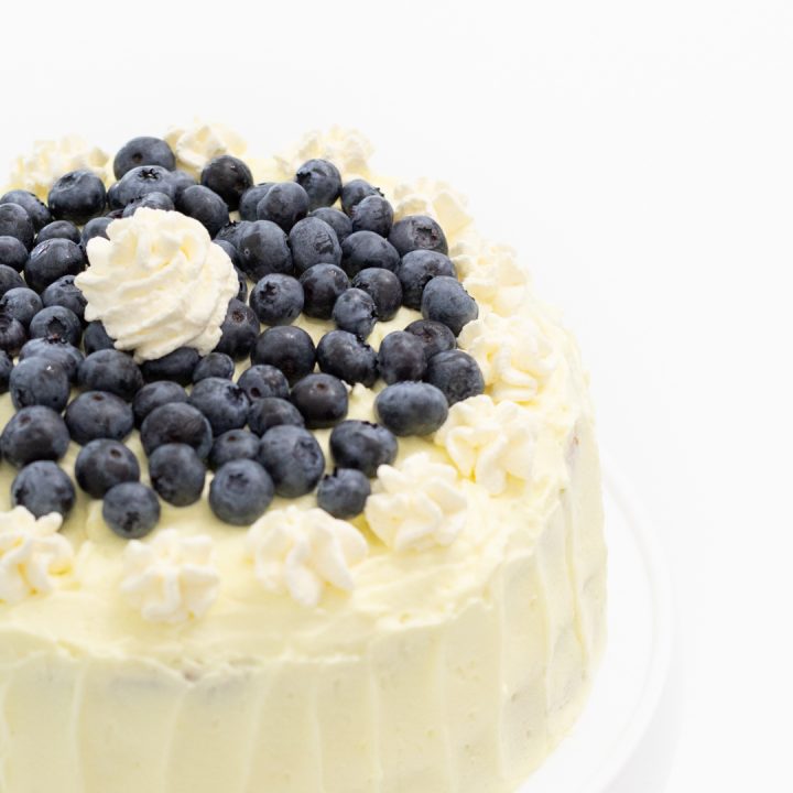Lemon frosted cake with fresh blueberries on top.