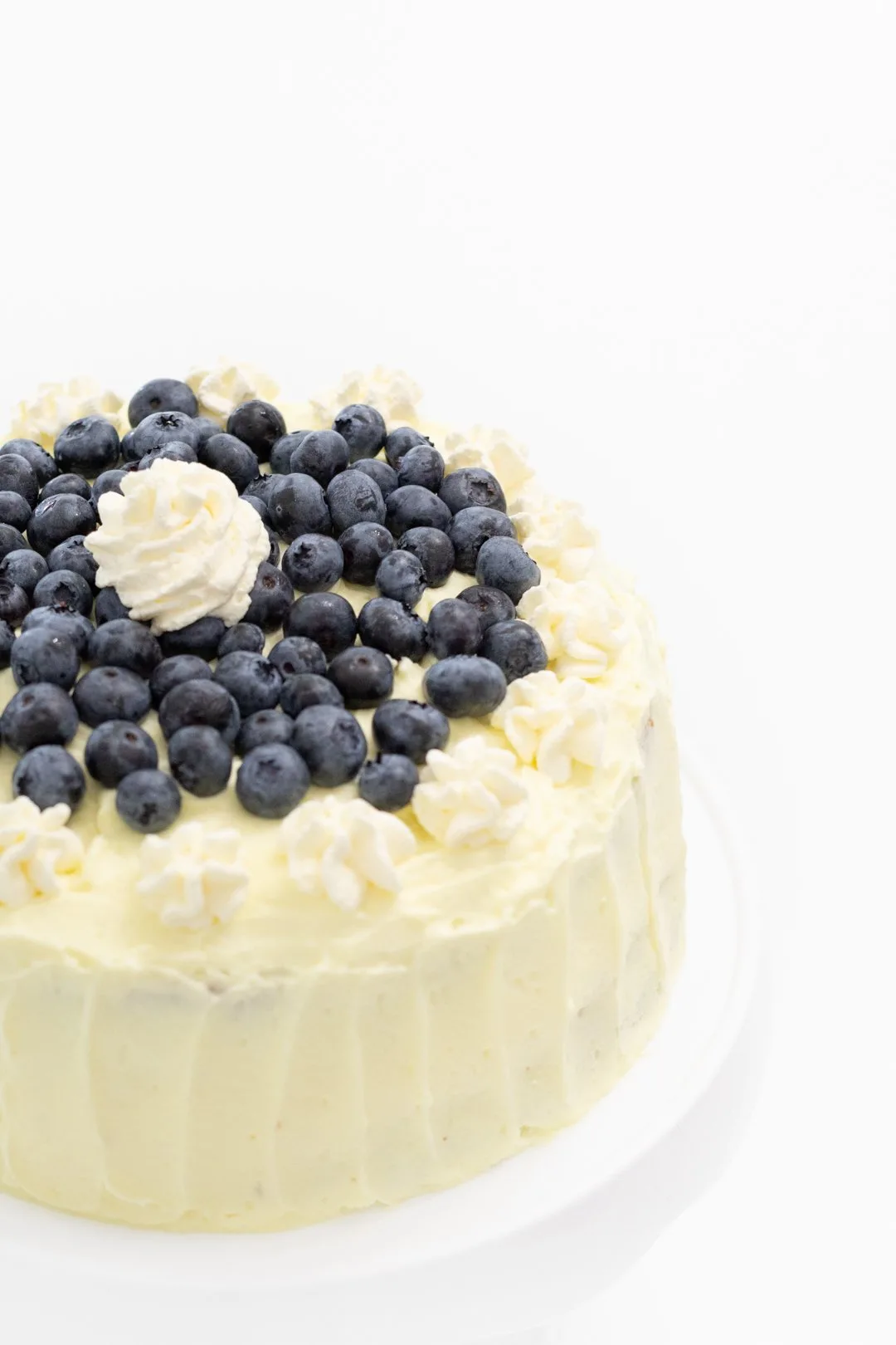 Lemon frosted cake with fresh blueberries on top.
