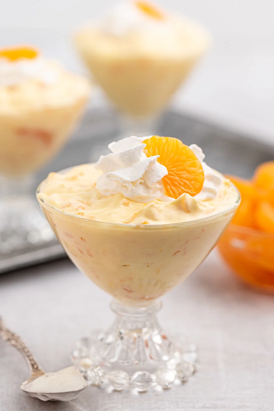 mandarin orange dessert with just three ingredients, served in vintage serving dishes. Topped with whipped cream and canned mandarin oranges.