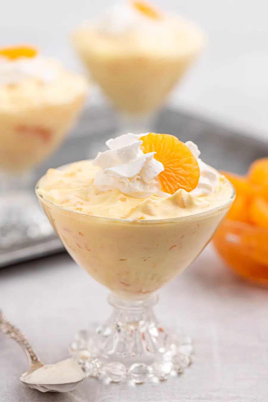 mandarin orange dessert with just three ingredients, served in vintage serving dishes. Topped with whipped cream and canned mandarin oranges.