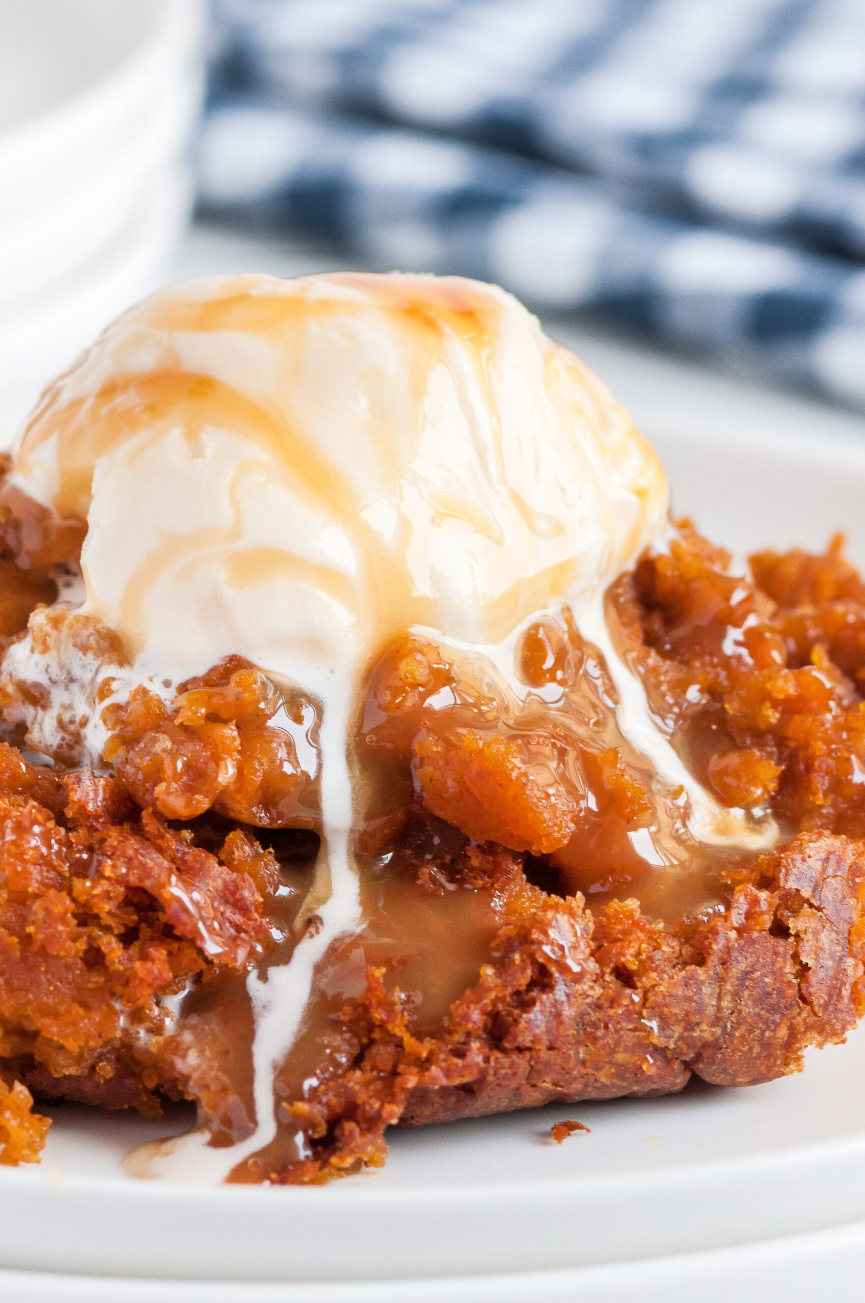 rich pumpkin cake served on a plate with melting ice cream