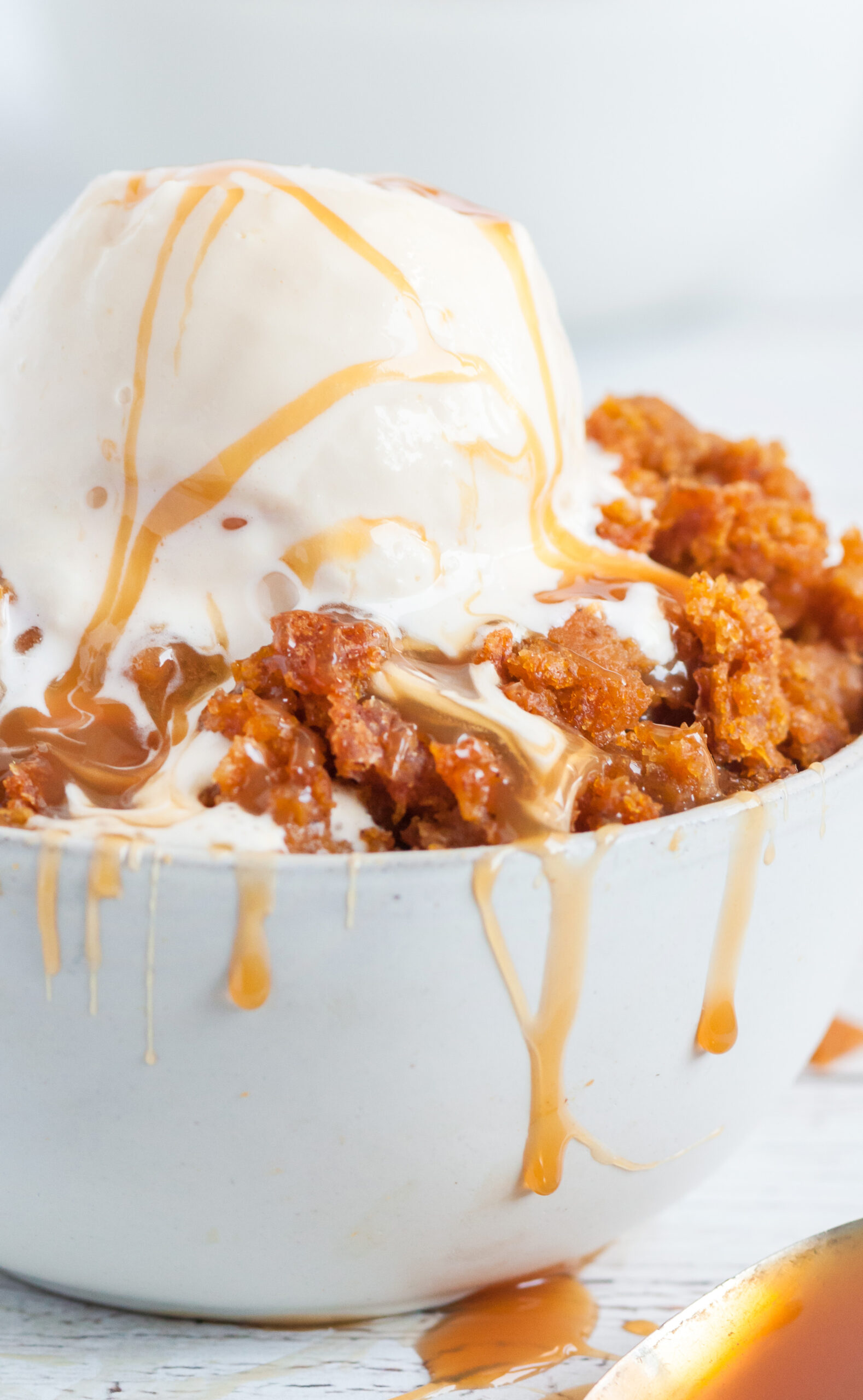 pumpkin dessert cake from slow cooker served in a bowl with ice cream and caramel