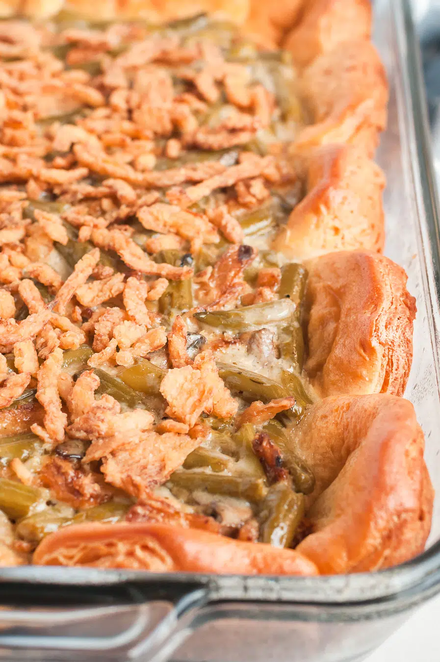 up close photo of a green bean casserole lined with biscuits