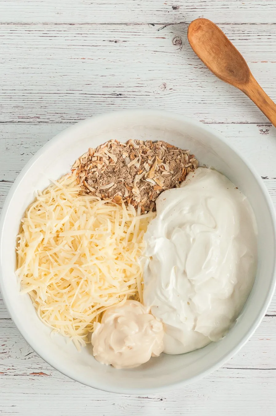 ingredients for french onion dip in a mixing bowl