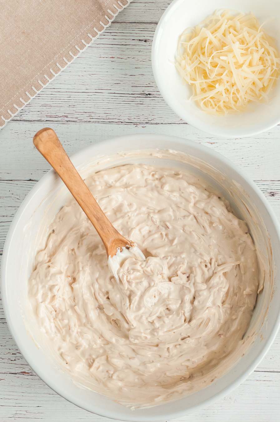 making french onion dip in a bowl with wooden spoon
