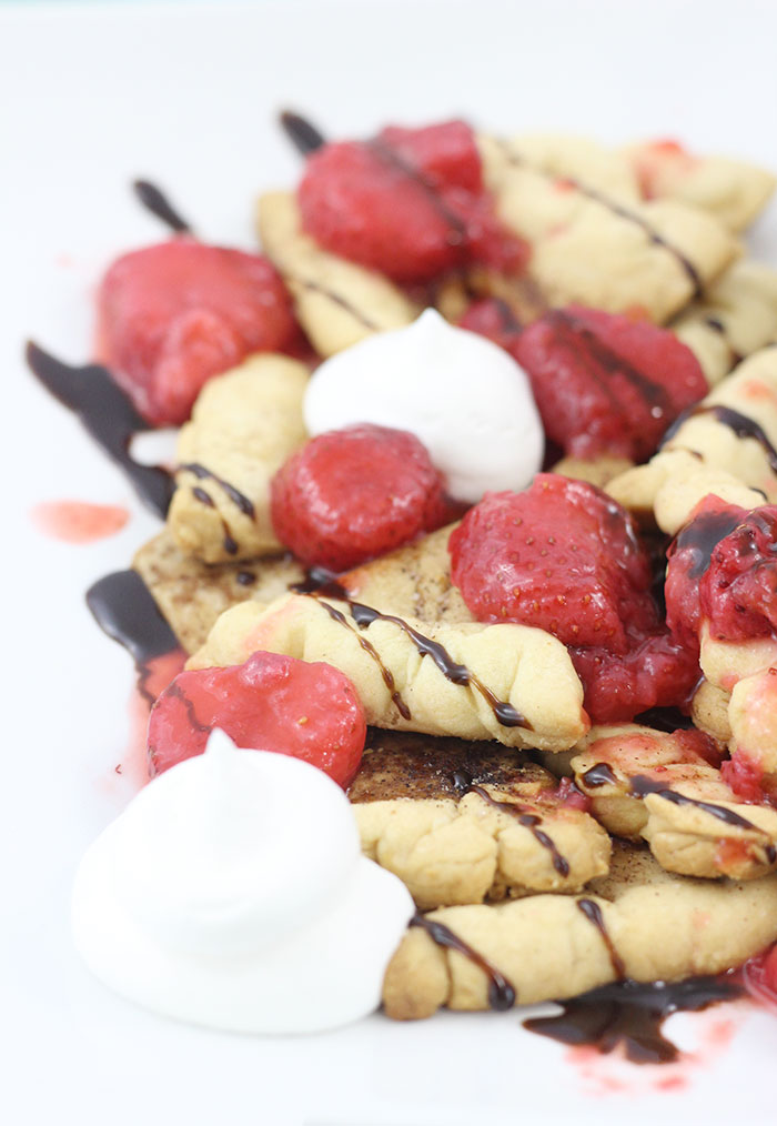 Pie Crust Nachos using baked Pie Crust cut into tortilla shaped and topped with Berry infused Whipped Topping, Strawberry sauce & Chocolate drizzle.