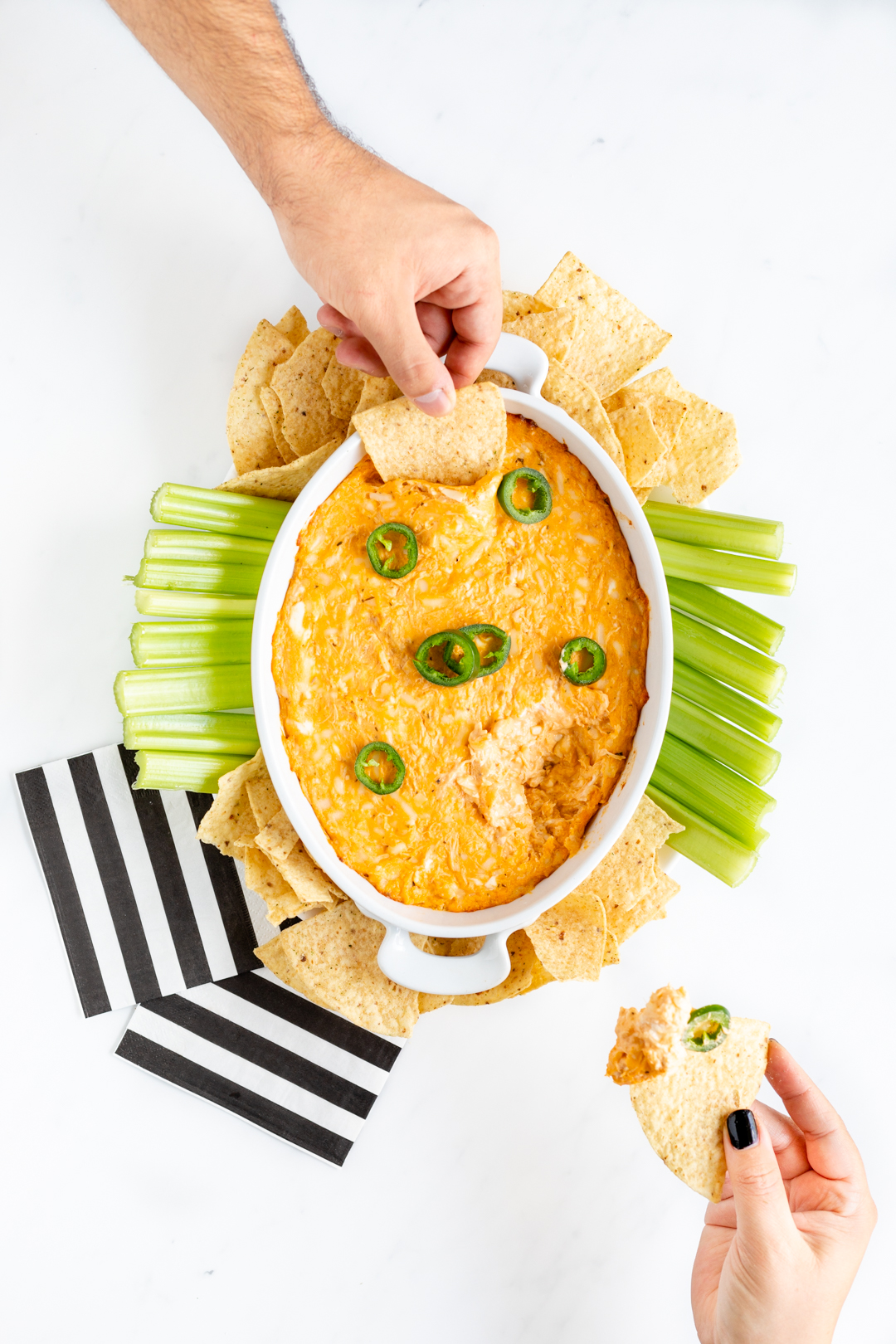 girl holding tortilla chip with dip