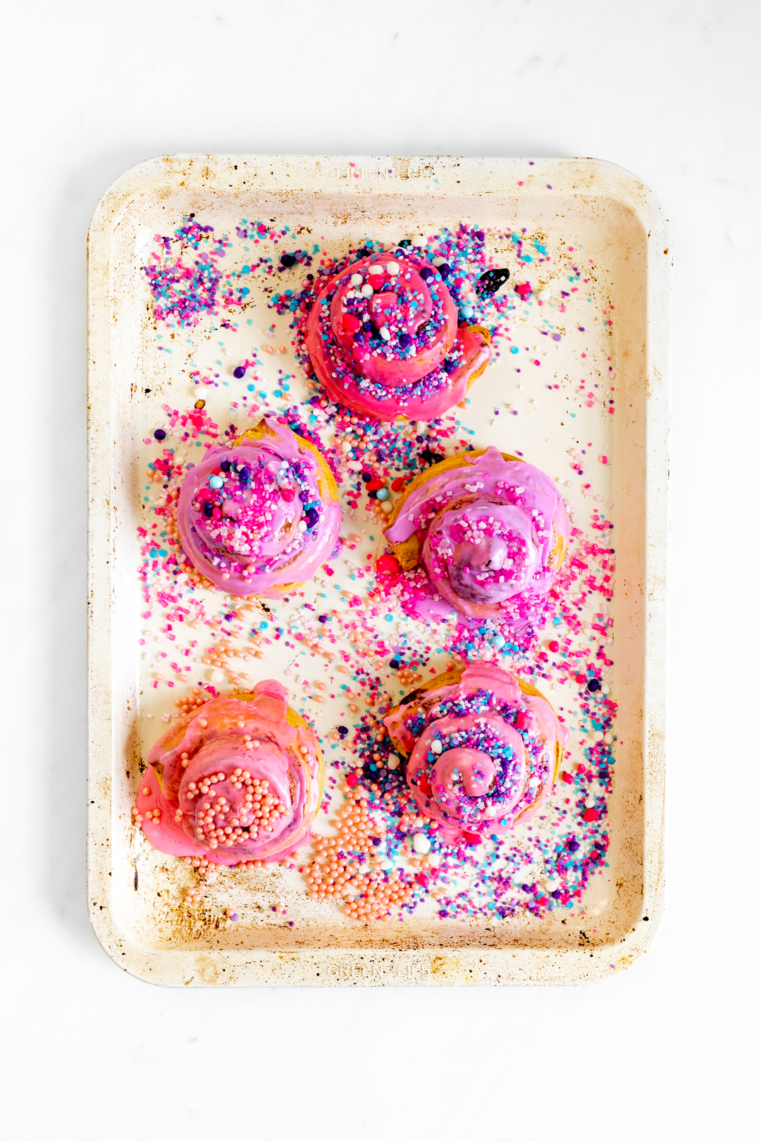 pink cinnamon rolls with colorful sprinkles