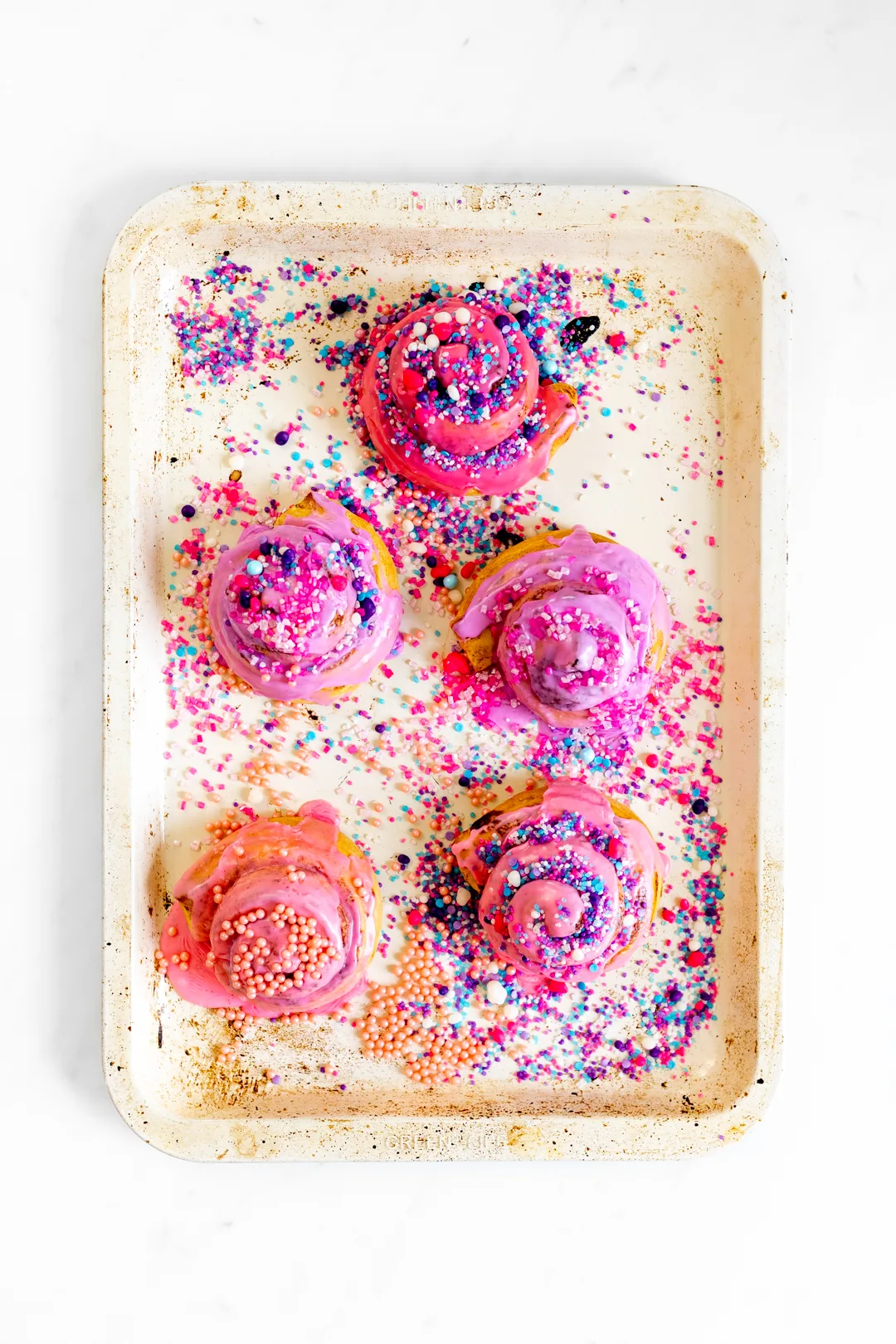 pink cinnamon rolls with colorful sprinkles
