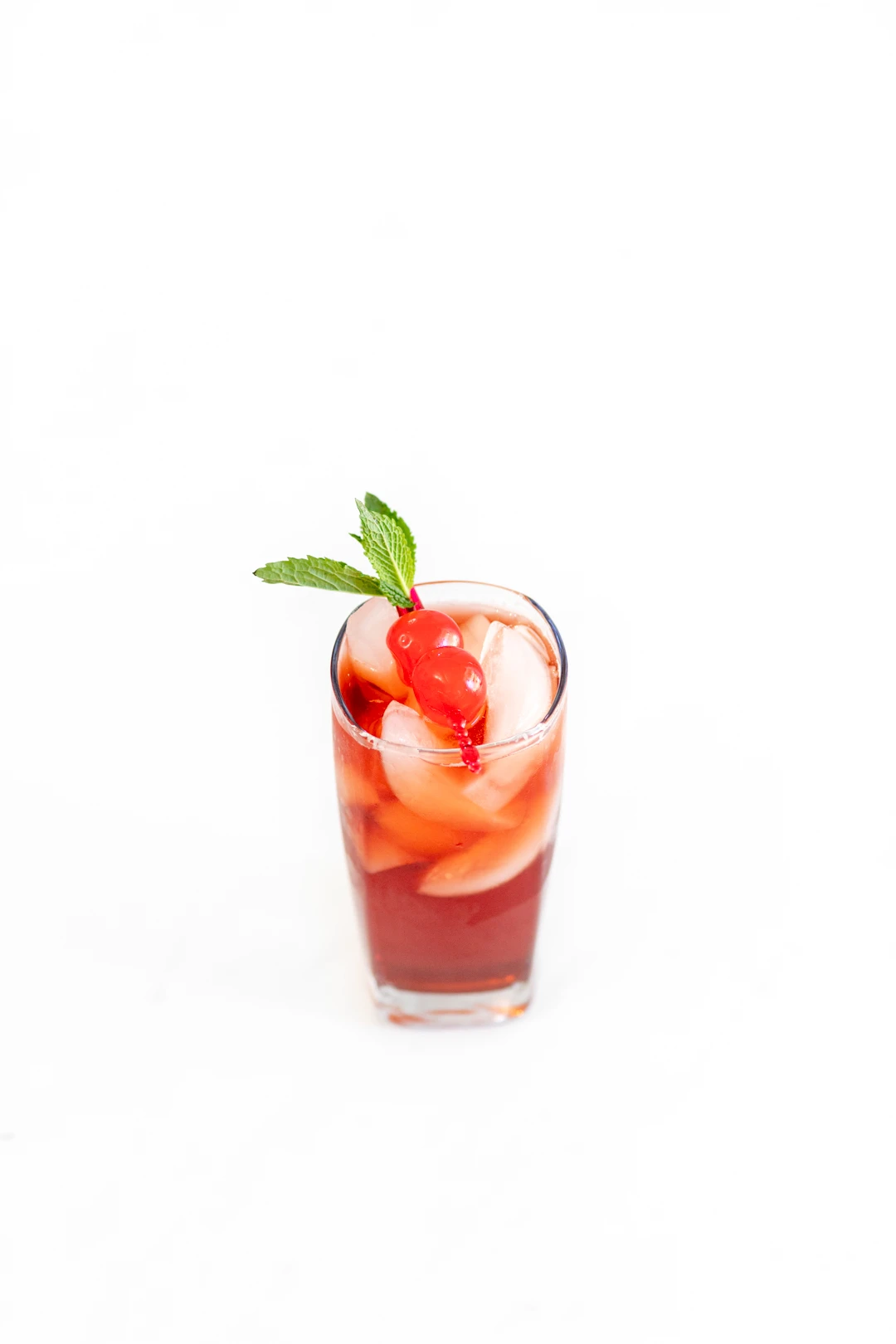 cherry iced tea with a cherry and mint garnish