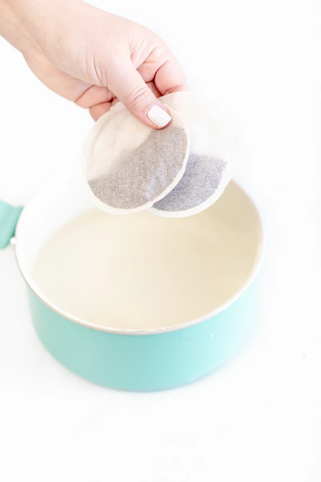 placing round iced tea bags into a potplacing round iced tea bags into a pot
