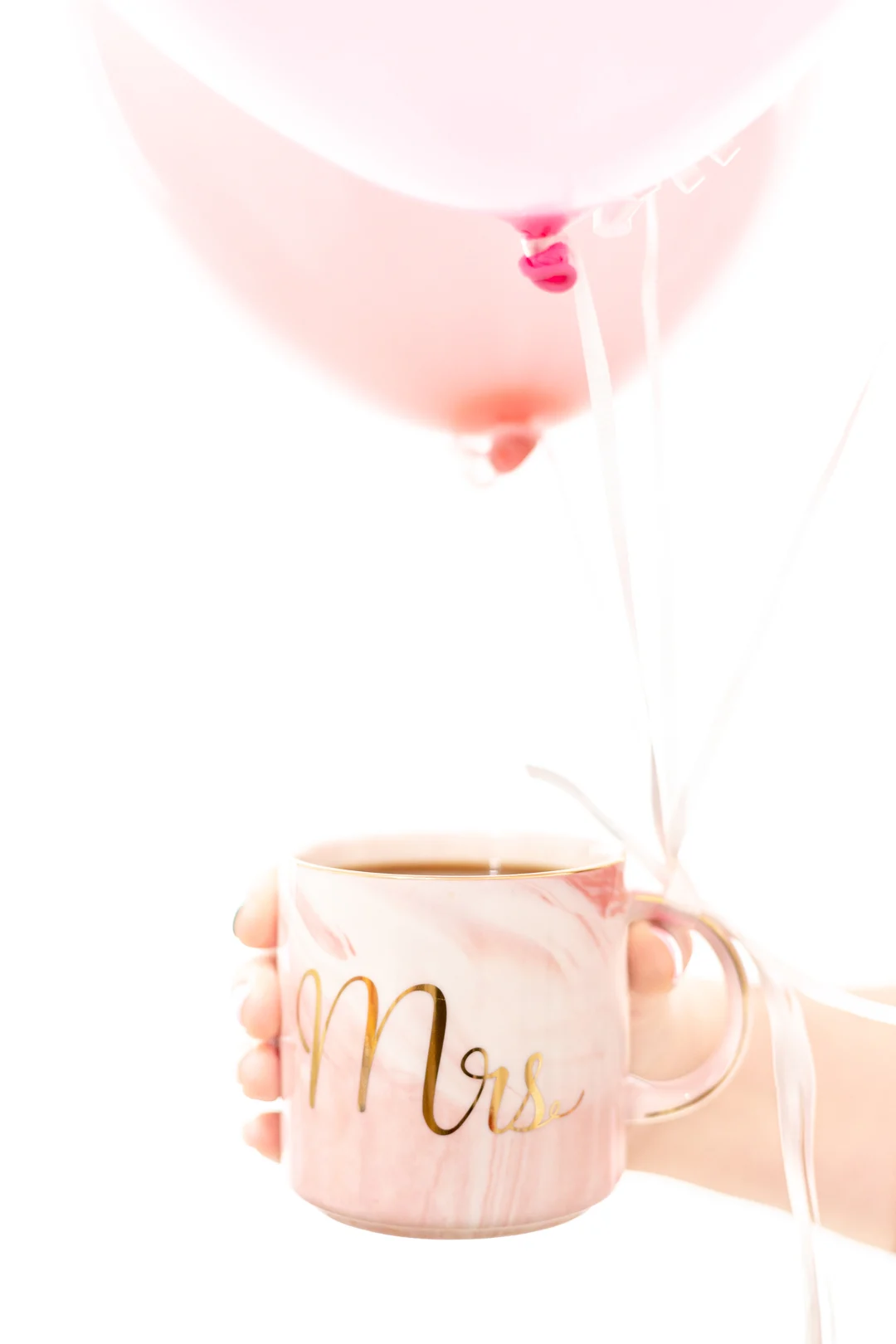 Mug of coffee with balloons tied to it for a surprise