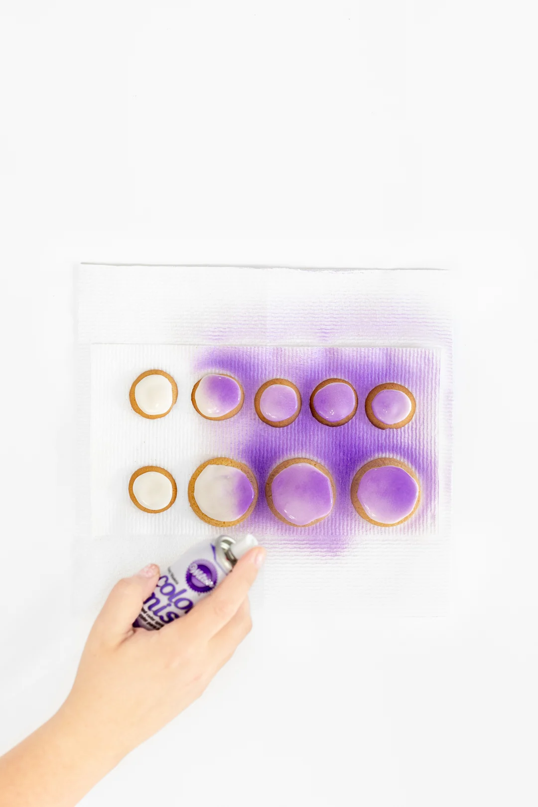 spraying edible purple mist onto cookies