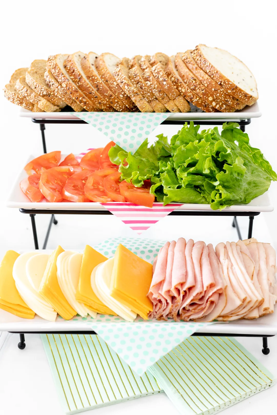 sandwich buffet station with bread, vegetables, cheese and meats.