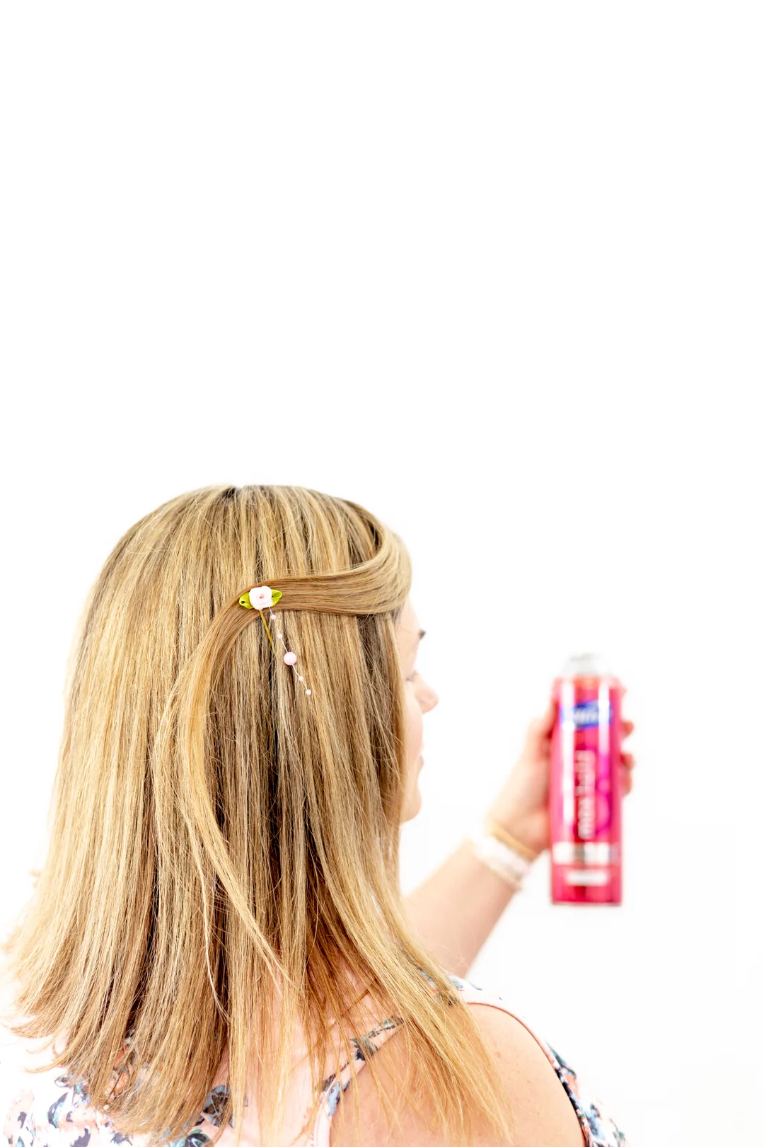 spraying hairspray onto spring hairstyle