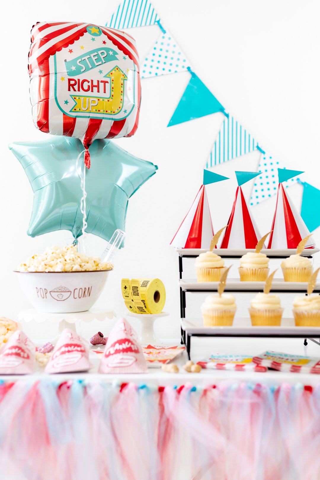 Carnival party table with cupcakes, balloons, popcorn and peanuts