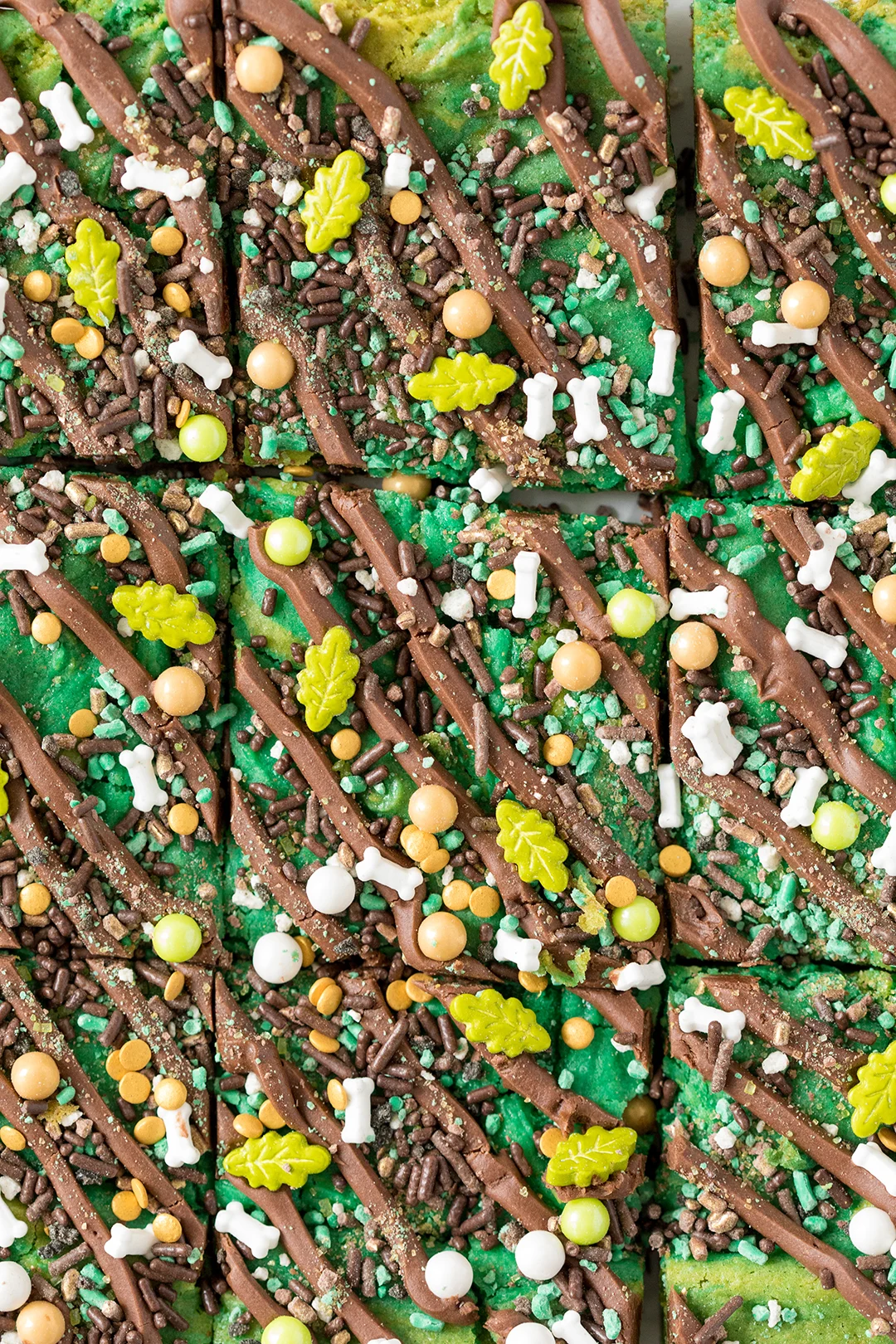 Dinosaur bars with drizzled chocolate frosting and edible dino sprinkles