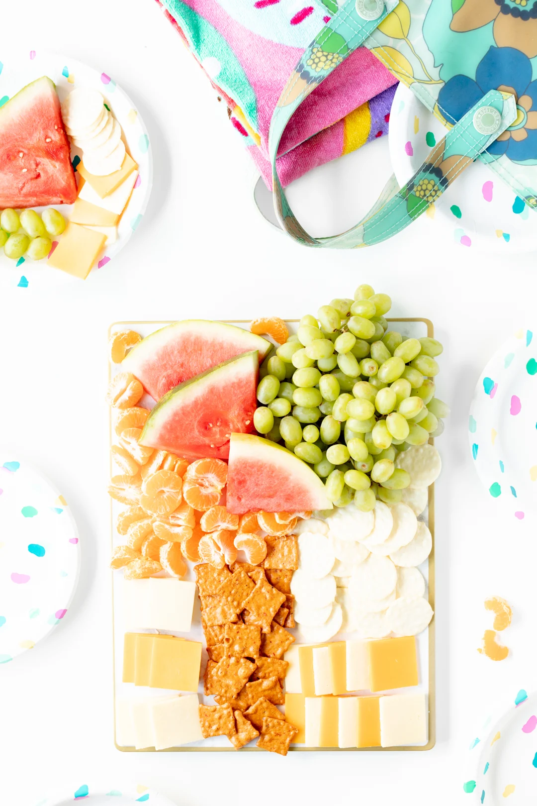 watermelon, grapes, mandarins, cheese and crackers on a tray