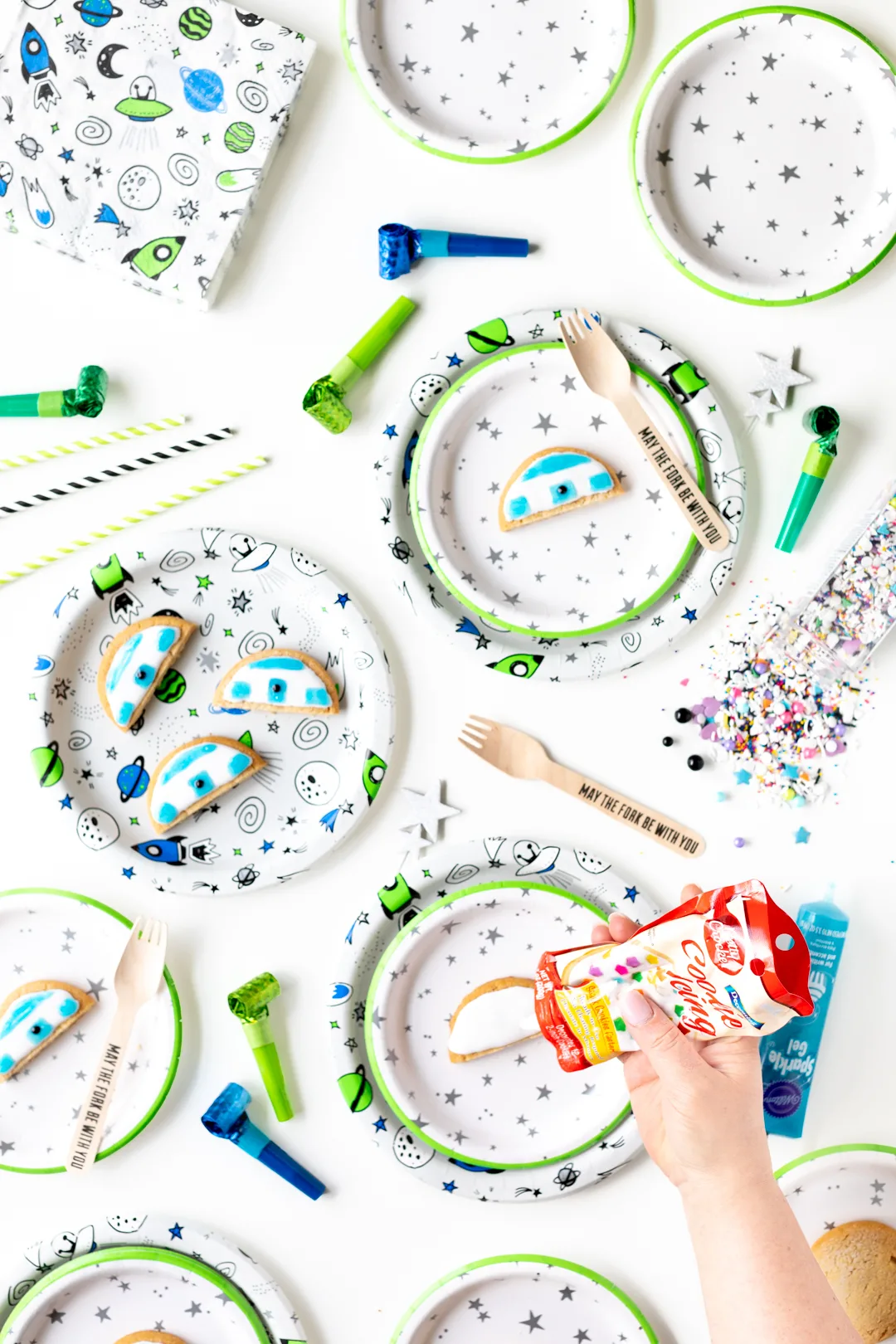 outer space party table with spaceship paper plates, forks and party poppers