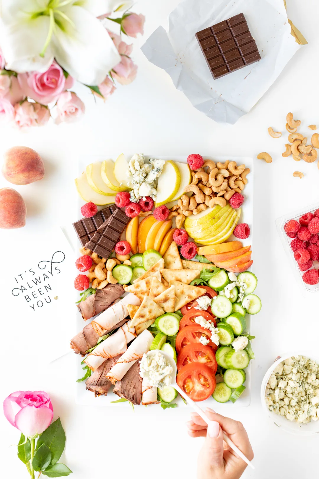 date night snack board with a variety of foods from pears, chocolate and raspberries.