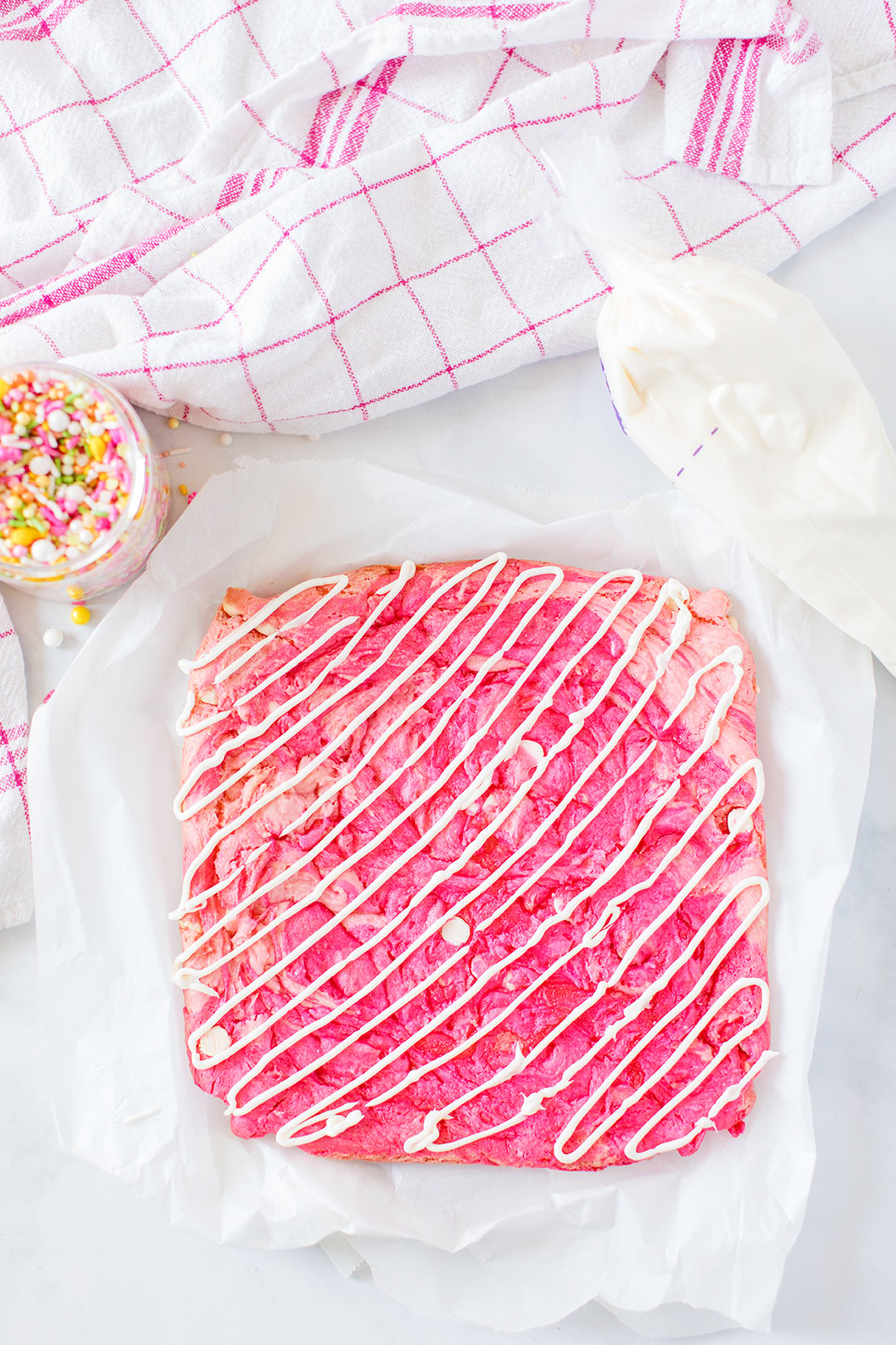 icing drizzled on top of pink dessert bars