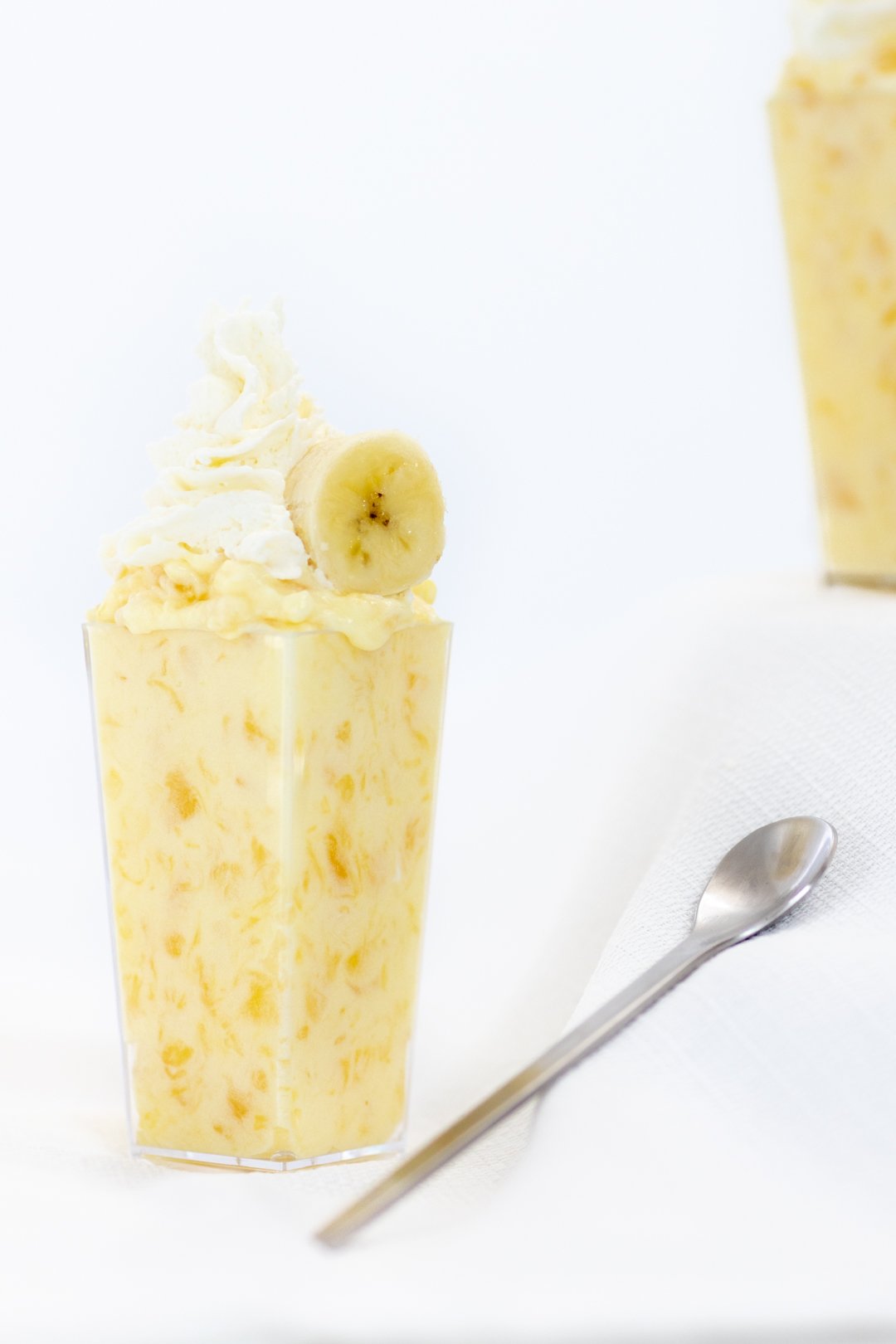 pineapple pudding topped with banana and whipped cream