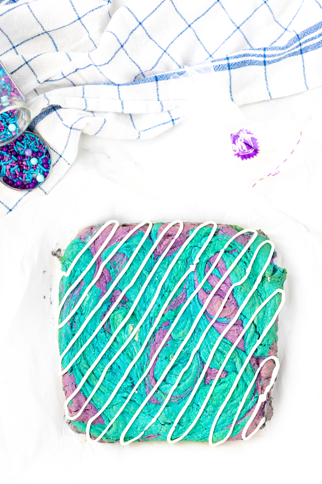 Icing drizzled on top of colorful purple and teal bars
