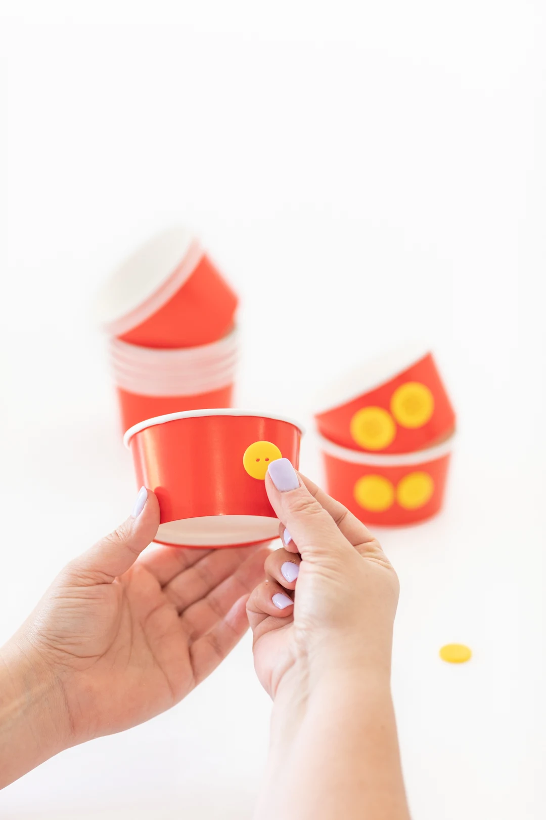 Press yellow buttons into red paper ice cream cups