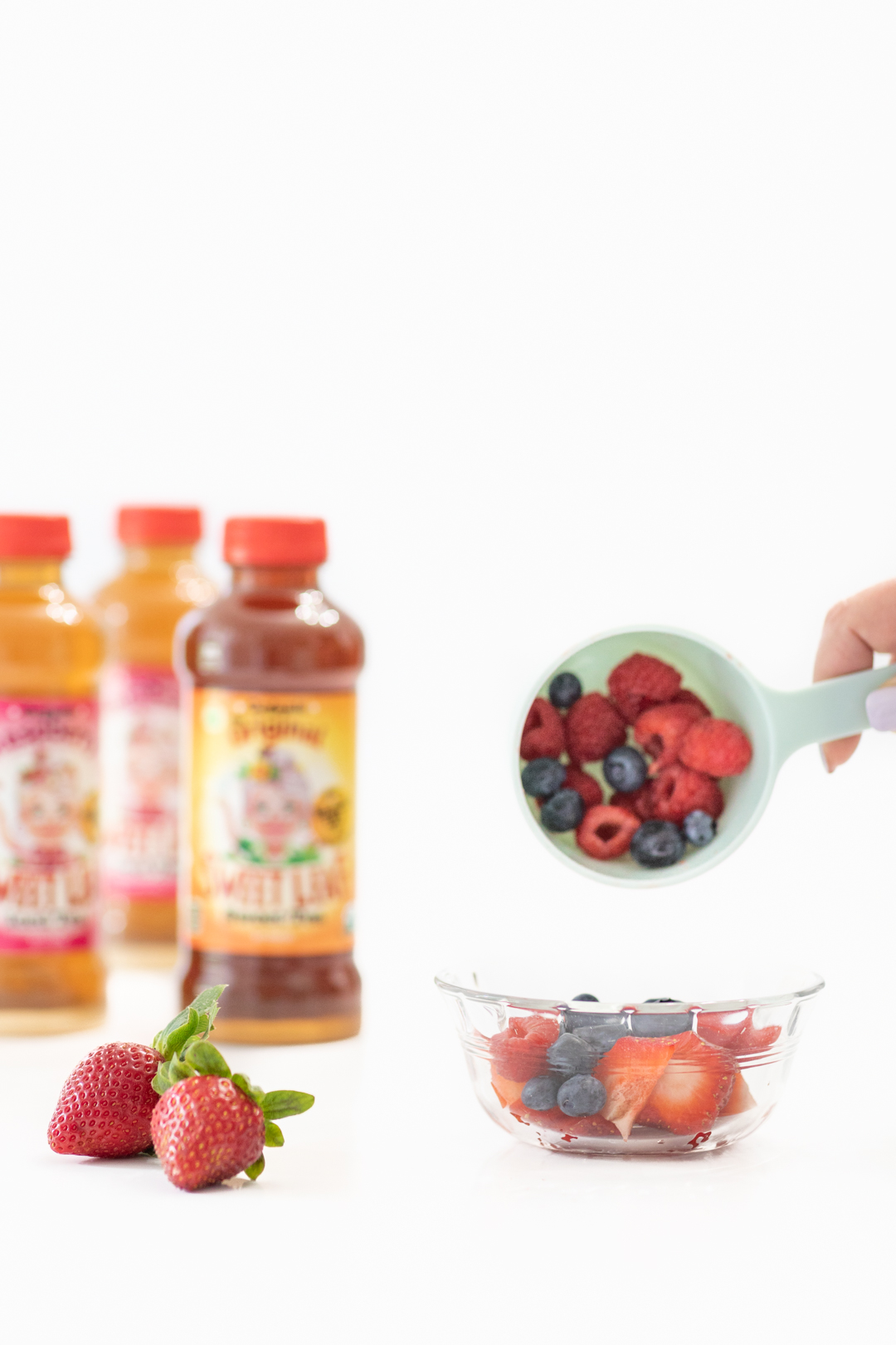 Pouring fresh berries into bowl.