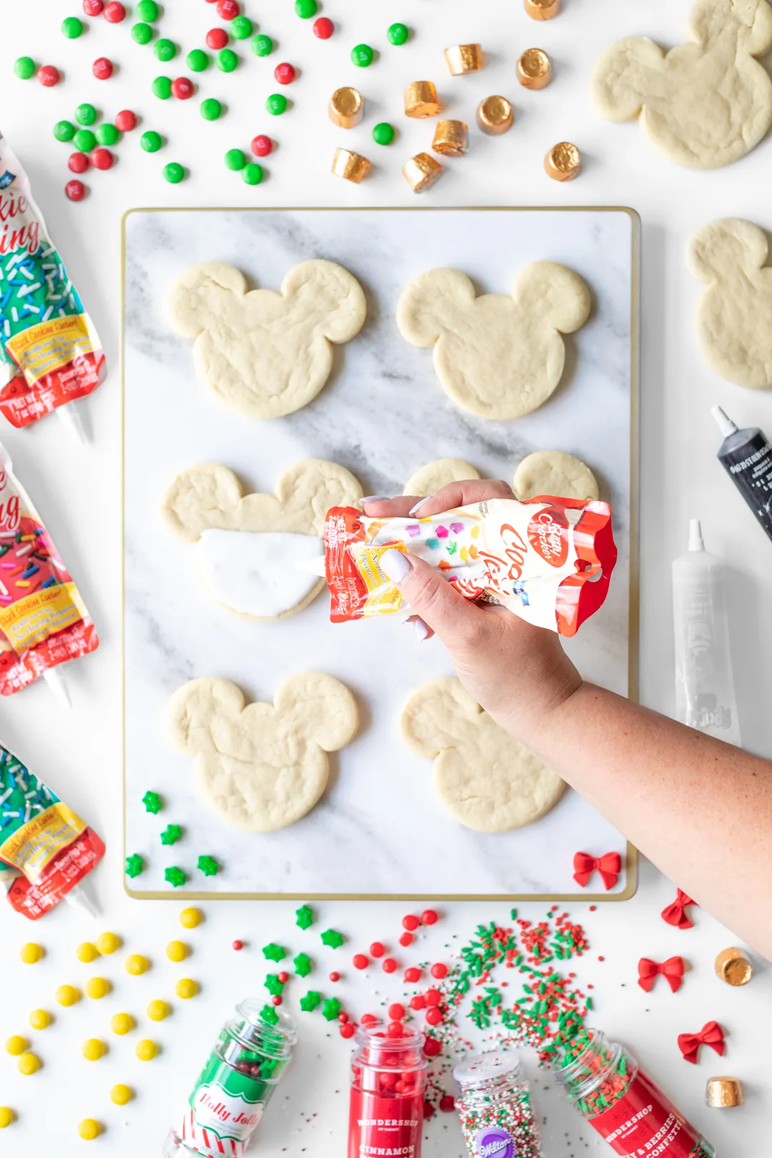 Adding icing onto Mickey Mouse cookie.