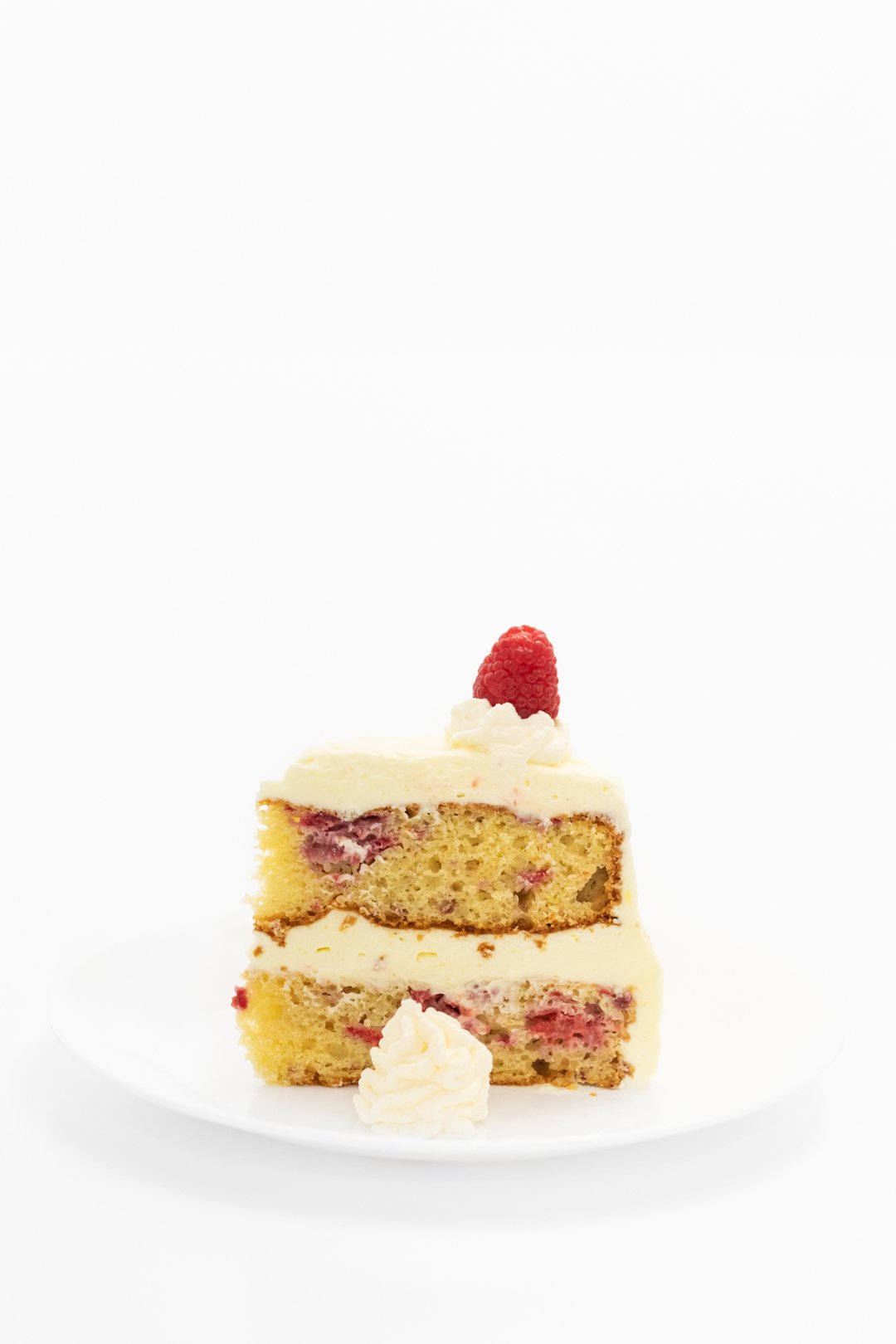 Pretty slice of fresh raspberry cake with lemon frosting.