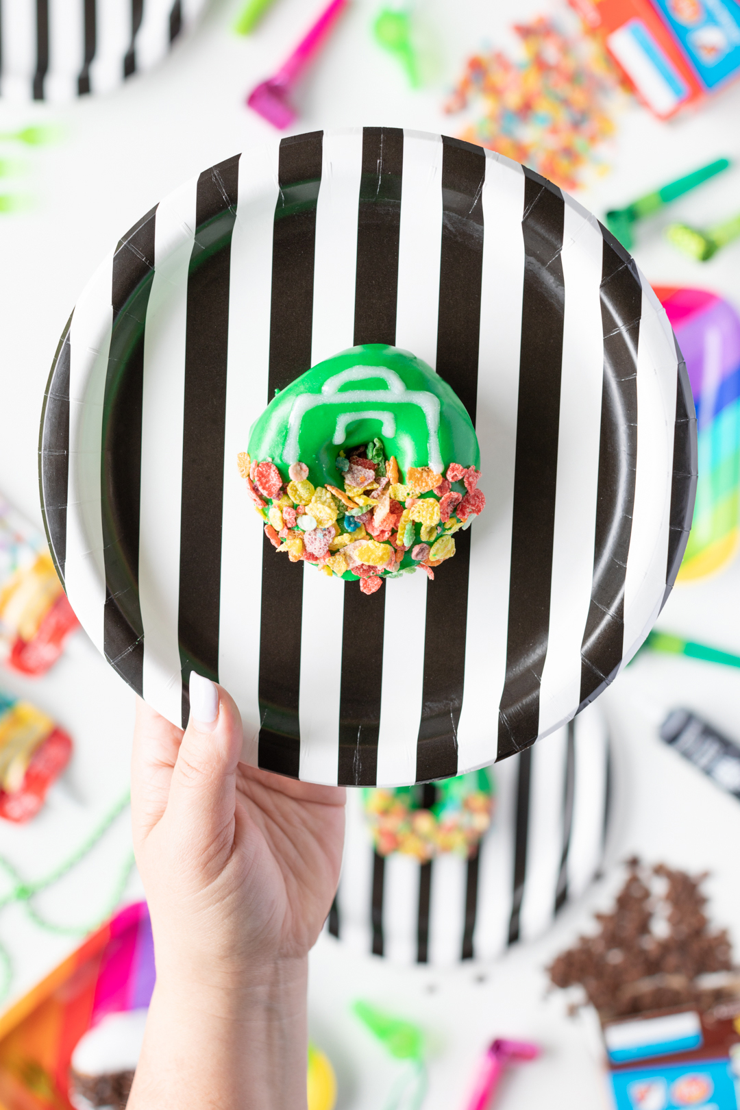 Soccer Goal Donut with Icing and Fruity Pebbles being held.